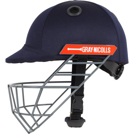 The Gray Nicolls Atomic Helmet is a lightweight navy blue cricket helmet with a metal face guard, black chin strap, and red Gray-Nicolls logo—ideal for junior players who want both protection and style.