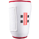 The Gray Nicolls Mini Soft Feel Armguard features a white design with red edging, black square patterns, the Gray Nicolls logo, and a white Velcro strap for secure cricket batting arm protection.