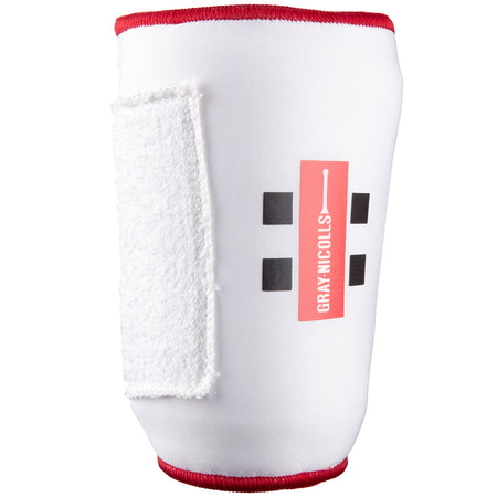 The Gray Nicolls Mini Soft Feel Armguard features a white design with red edging, black square patterns, the Gray Nicolls logo, and a white Velcro strap for secure cricket batting arm protection.