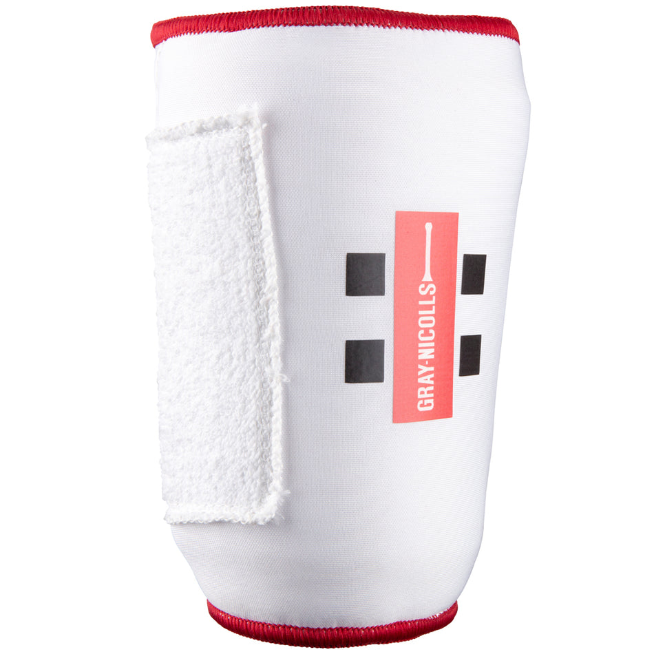 The Gray Nicolls Mini Soft Feel Armguard features a white design with red edging, black square patterns, the Gray Nicolls logo, and a white Velcro strap for secure cricket batting arm protection.