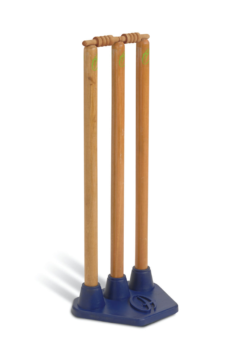 Three Harrod Sport Pro Flex Cricket Stumps with bails stand upright in blue rubber bases on a blue platform, casting shadows to the left.
