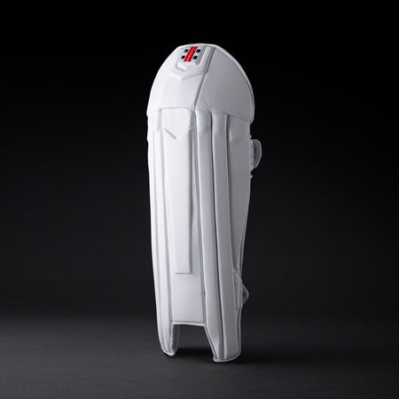The Gray Nicolls Legend Wicket Keeping Pads 2026, featuring an ergonomic knee design and subtle logo near the top, stands upright on a dark background highlighting its white padding and secure straps.