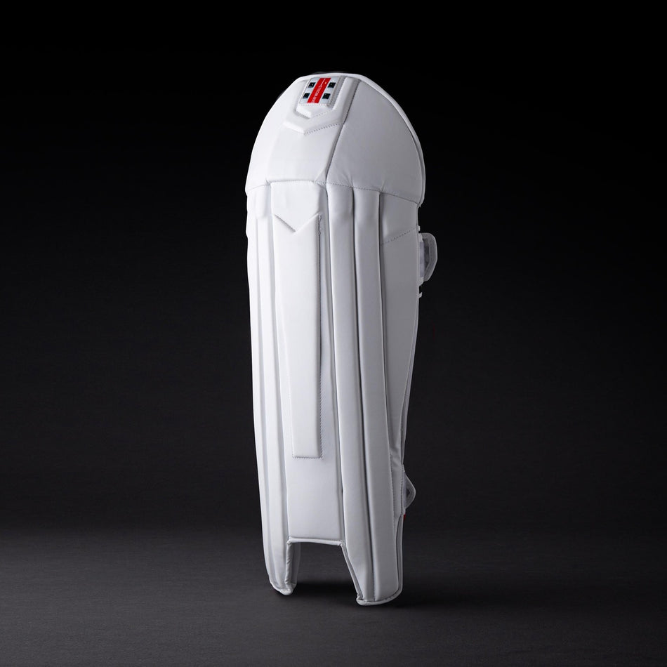 The Gray Nicolls Legend Wicket Keeping Pads 2026, featuring an ergonomic knee design and subtle logo near the top, stands upright on a dark background highlighting its white padding and secure straps.