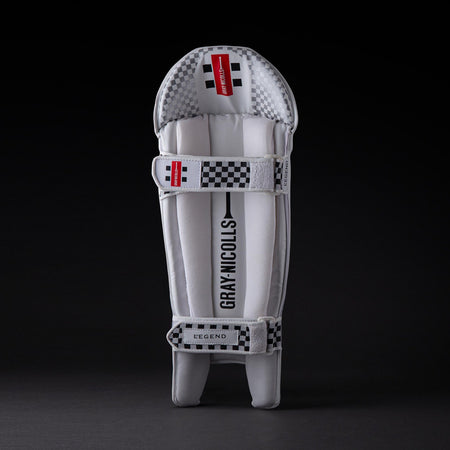 A single Gray Nicolls Legend Wicket Keeping Pad 2026 in white and gray with checkered black and white accents, ergonomic knee design, and "Gray Nicolls" branding on the front, displayed against a dark background.