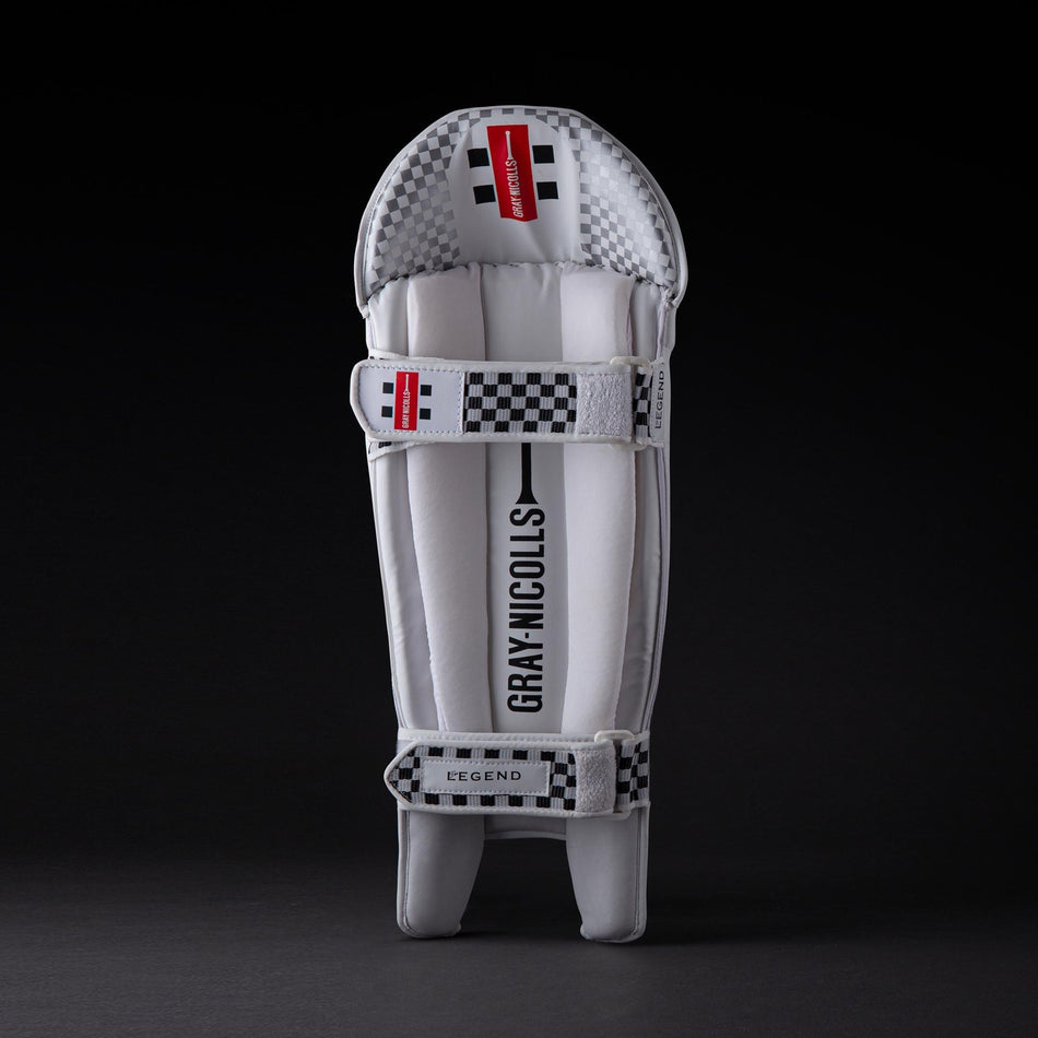 A single Gray Nicolls Legend Wicket Keeping Pad 2026 in white and gray with checkered black and white accents, ergonomic knee design, and "Gray Nicolls" branding on the front, displayed against a dark background.