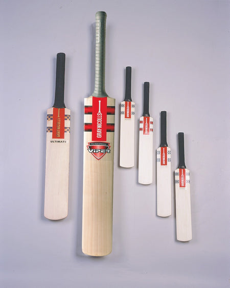 Ten Gray Nicolls Miniature Cricket Bats from the assorted pack are displayed upright against a light gray background, showcasing various labels and designs with the largest bat in the center.