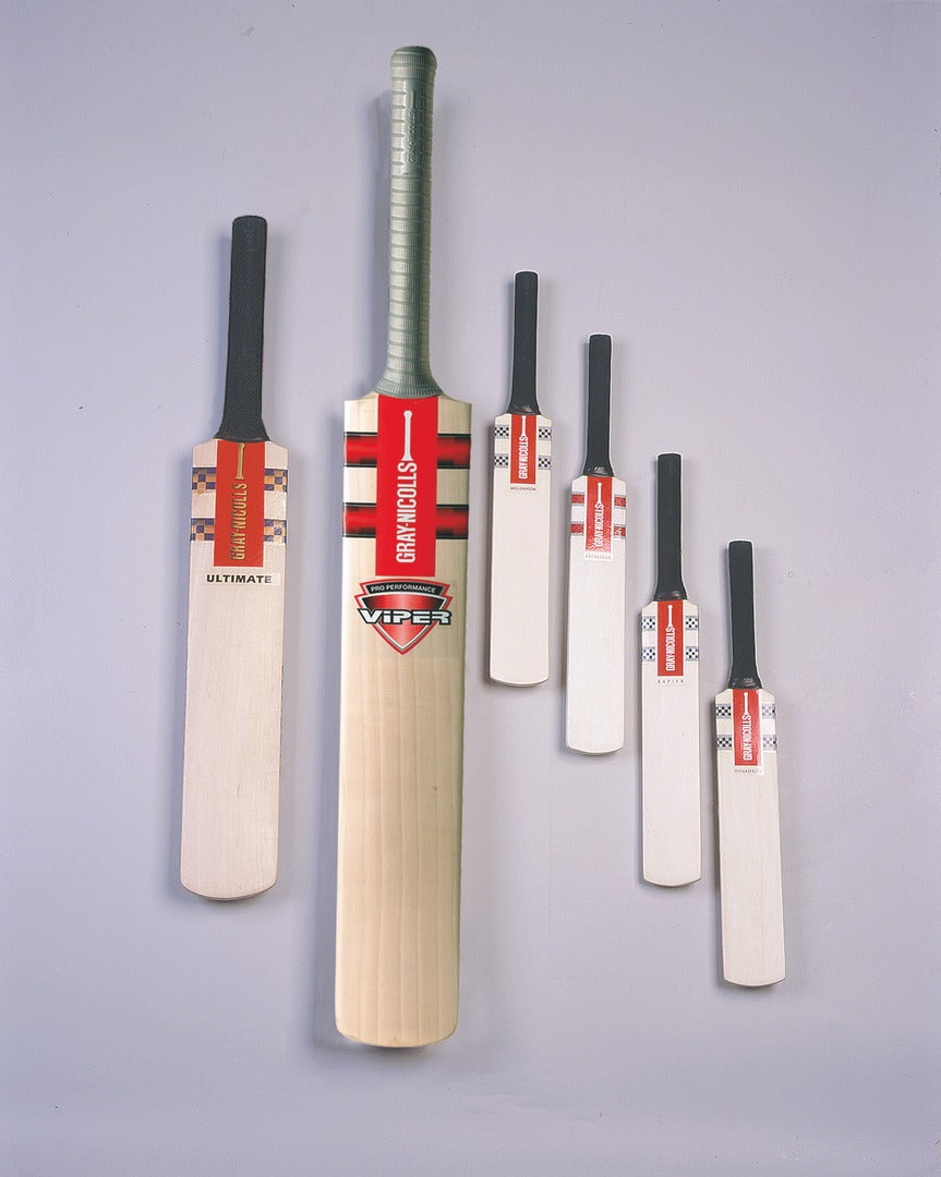 Ten Gray Nicolls Miniature Cricket Bats from the assorted pack are displayed upright against a light gray background, showcasing various labels and designs with the largest bat in the center.