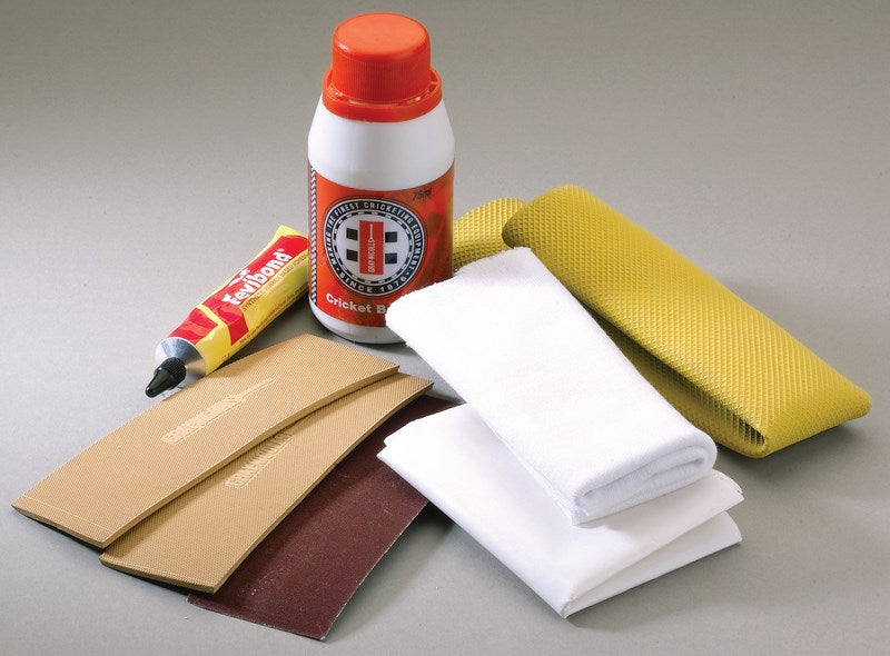 The Gray Nicolls Bat Repair Kit includes adhesive, liquid, sandpaper, white cloths, and yellow grip tape—perfect for complete cricket bat maintenance on any surface.