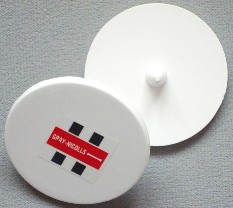 Two Gray Nicolls Bowlers Markers—one showing the red and black Gray Nicolls logo and the other revealing its central knob—rest on a gray surface, ideal for marking run-ups or use during training sessions.