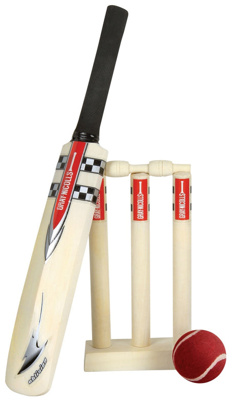The Gray Nicolls Mini Game International children’s cricket set, featuring a bat, three wooden stumps with bails on a base, and a red ball, is displayed against a white background.