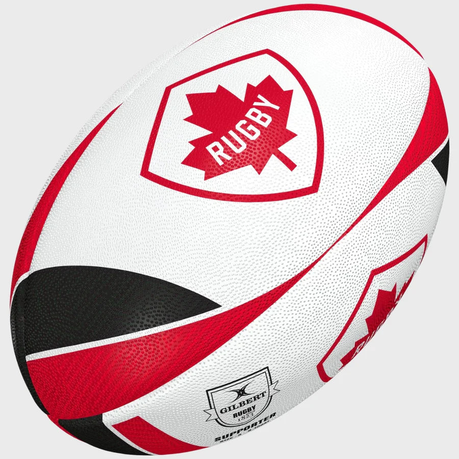 The Gilbert Canada Supporter Rugby Ball by Gilbert is a white size 5 ball with red and black accents, a red maple leaf emblem labeled RUGBY, and the Gilbert logo—ideal as Rugby Canada memorabilia.