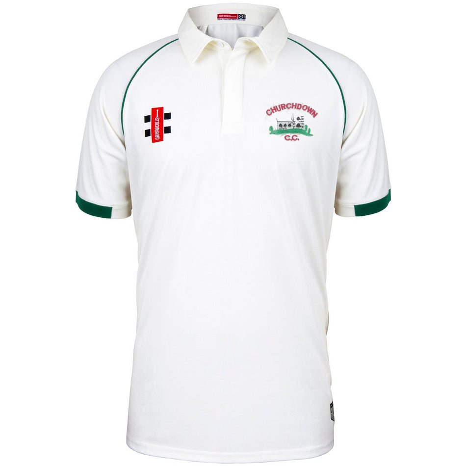 The Churchdown CC Matrix V2 Short Sleeve Match Shirt by Martin Berrill Sports is a white shirt with green trim, featuring embroidered Churchdown CC logos on the chest and a bold red and black badge.