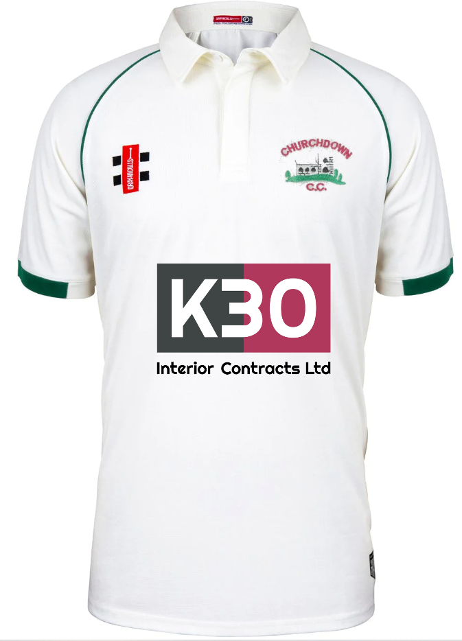 The Churchdown CC Matrix V2 Junior S/S Match Shirt by Martin Berrill Sports is a white cricket shirt with green-trimmed sleeves, sponsor logos, and CHURCHDOWN C.C. above a green cricket scene—perfect for official match play.