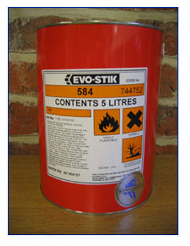 A large red can of Martin Berrill Sports Cricket Matting Adhesive (5 litres), marked with flammability and harmful substance warnings, is shown outdoors in front of a brick wall.