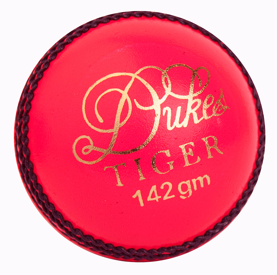 A close-up of a pink Dukes Tiger Junior Coloured Cricket Ball with gold text and black stitching on the seam, perfect for junior cricket.