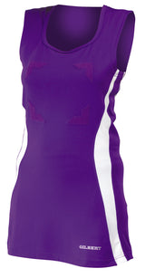 The Gilbert Eclipse Netball Dress by Gilbert comes in purple/white, features sleeveless design, white side panels, chest arrow-shaped patches, and GILBERT branding at the bottom—ideal as a women's netball uniform.
