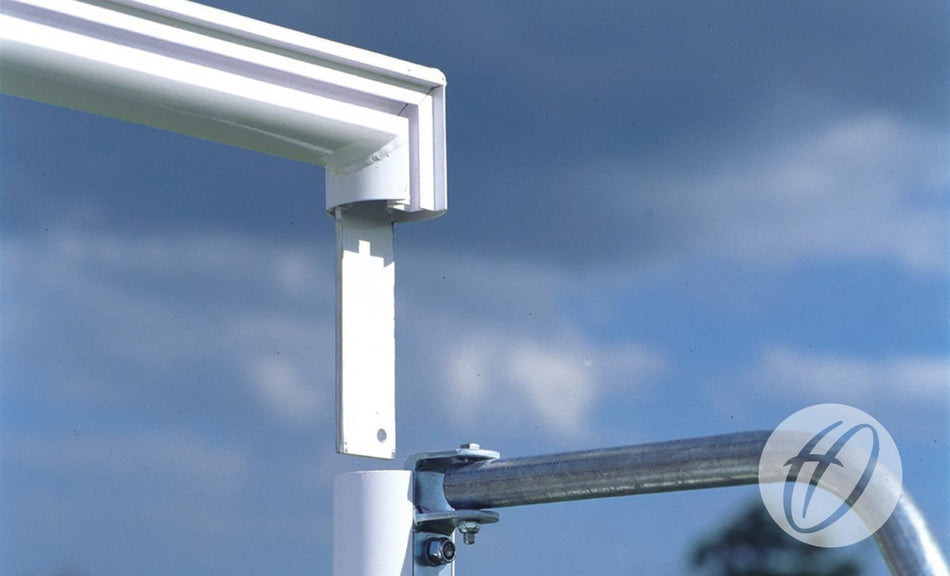 Close-up of a white metal fixture joining the horizontal and vertical poles beneath a cloudy sky, showcasing the robust build quality of the Harrod Sport Freestanding Aluminium 5-a-side Football Goal (4.88m x 1.22m), with the brand logo visible in the bottom right corner.