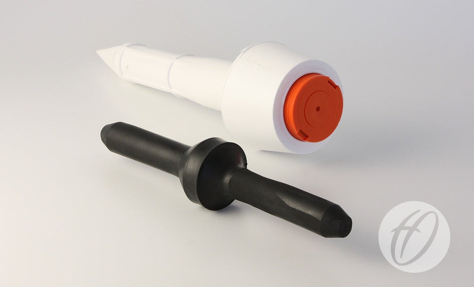 Two objects rest on a white surface: a Harrod Sport Socket & Cap for Spring Back Corner Pole, featuring a white pole with an orange cap, and a black cylindrical socket with a flared middle. A faint circular logo appears in the bottom right corner.