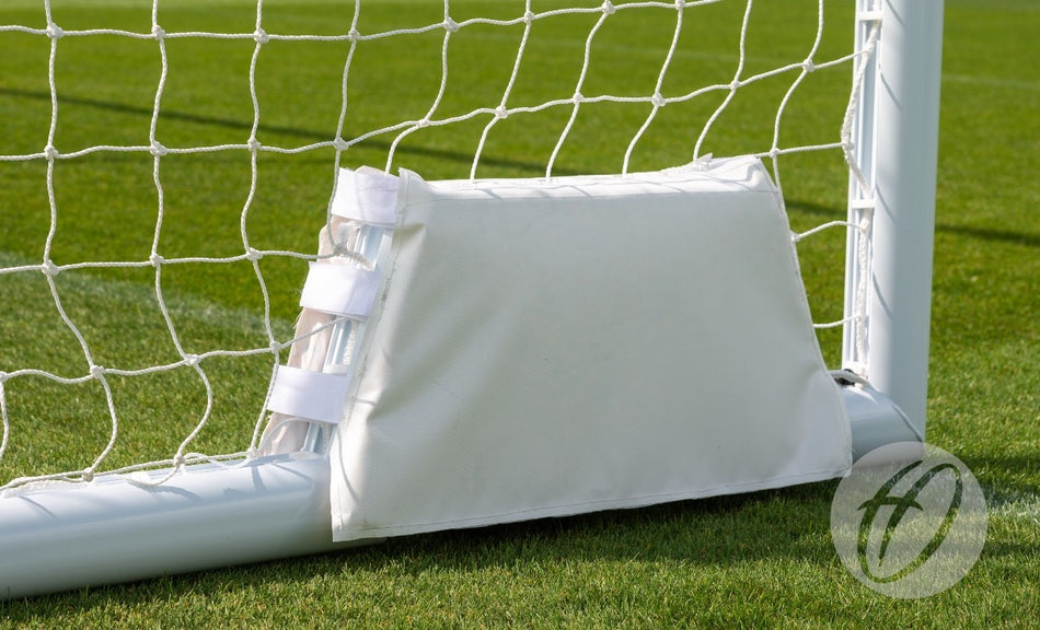 A Harrod Sport 4G Swivel Portagoal - Wheel Protection Pad is shown attached to the bottom corner of a soccer goalpost on green grass, with netting visible in the background.
