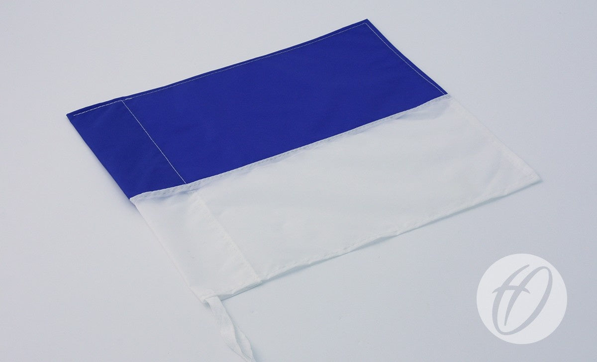 A Harrod Sport Royal Blue & White Horizontal Flag (30cm x 30cm) lies flat on a light surface, with a small left-edge loop, circular logo in the bottom right, and flexible PVC corner poles for easy display.