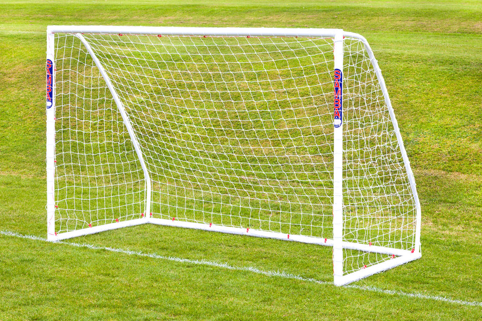 A Samba Sports Futsal Match Goal 3m x 2m with a net is set up on green grass. Its high-impact uPVC frame and red and blue branding stand out against the well-maintained field.