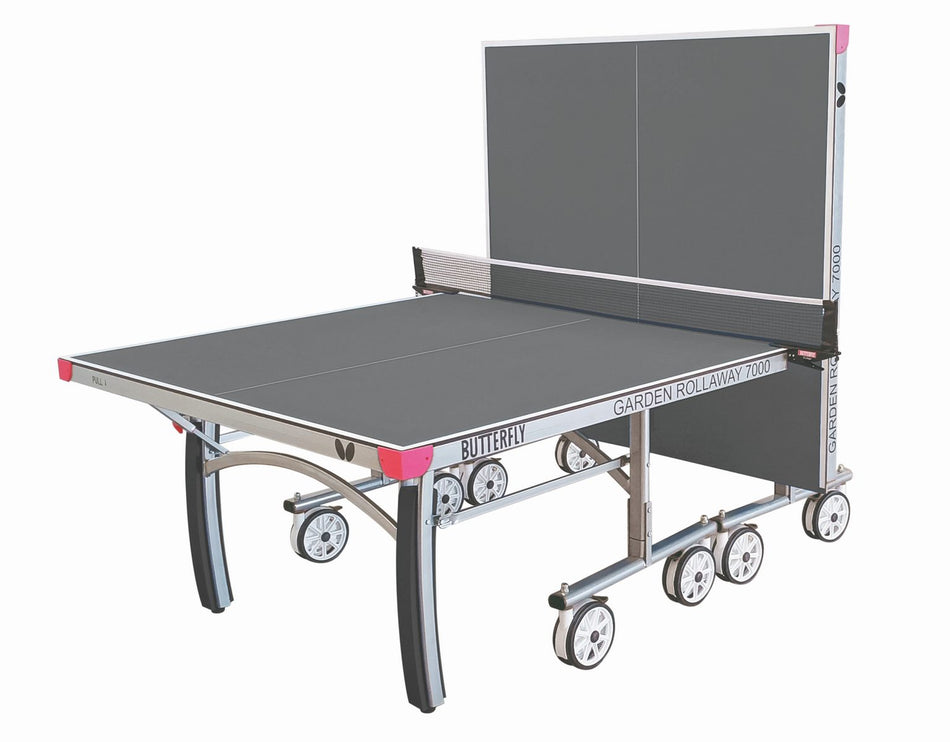 The Butterfly Garden Rollaway 7000 Outdoor Table Tennis Table (Grey) features a durable 7mm melamine top, sturdy metal frame, wheels, and net. Shown partially folded for solo play or compact storage.