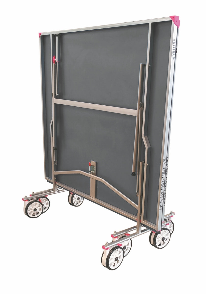 The Butterfly Garden Rollaway 40 Table Tennis Table (Grey) by Butterfly features a foldable metal frame, gray anti-glare melamine surface, pink corner accents, and wheels for easy storage and mobility in an upright position.
