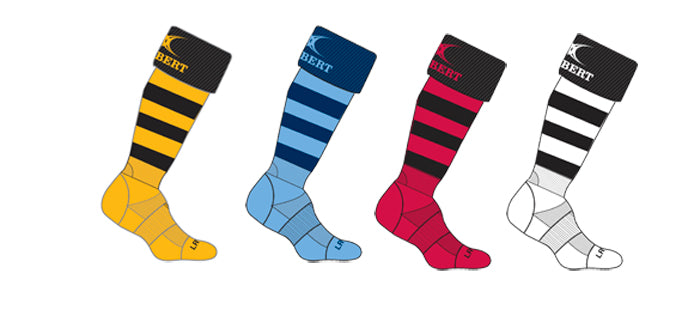 The Gilbert Kryten II Hooped Socks by Gilbert come in amber with black stripes, featuring a ribbed ankle, cushioned sole, BERT design, and a curved logo at the top.