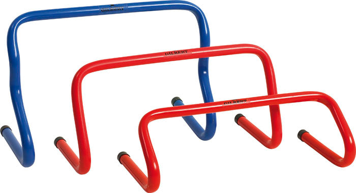 Three Gilbert Step Hurdle 12 inch, two red and one blue, are arranged side by side. These hurdles from Gilbert feature curved metal frames and rubber-capped feet, perfect for plyometric jumps and agility drills.