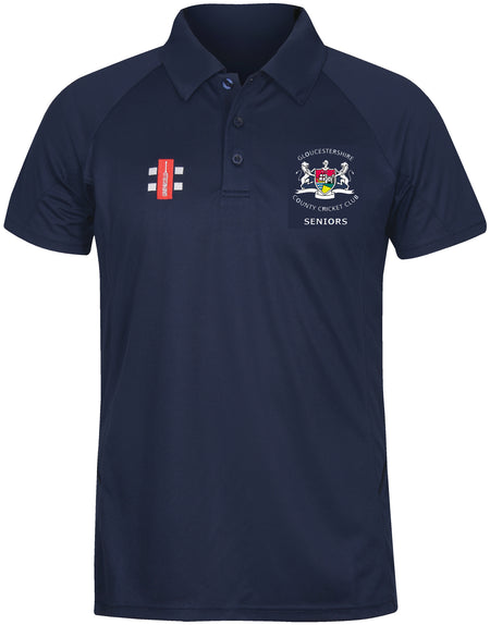 The Gray Nicolls Gloucestershire CCC Seniors Matrix V2 Polo Shirt is a navy short-sleeve polo with a collar, featuring the Seniors logo on the left chest and a red and white emblem on the right. Made for moisture-controlling comfort.