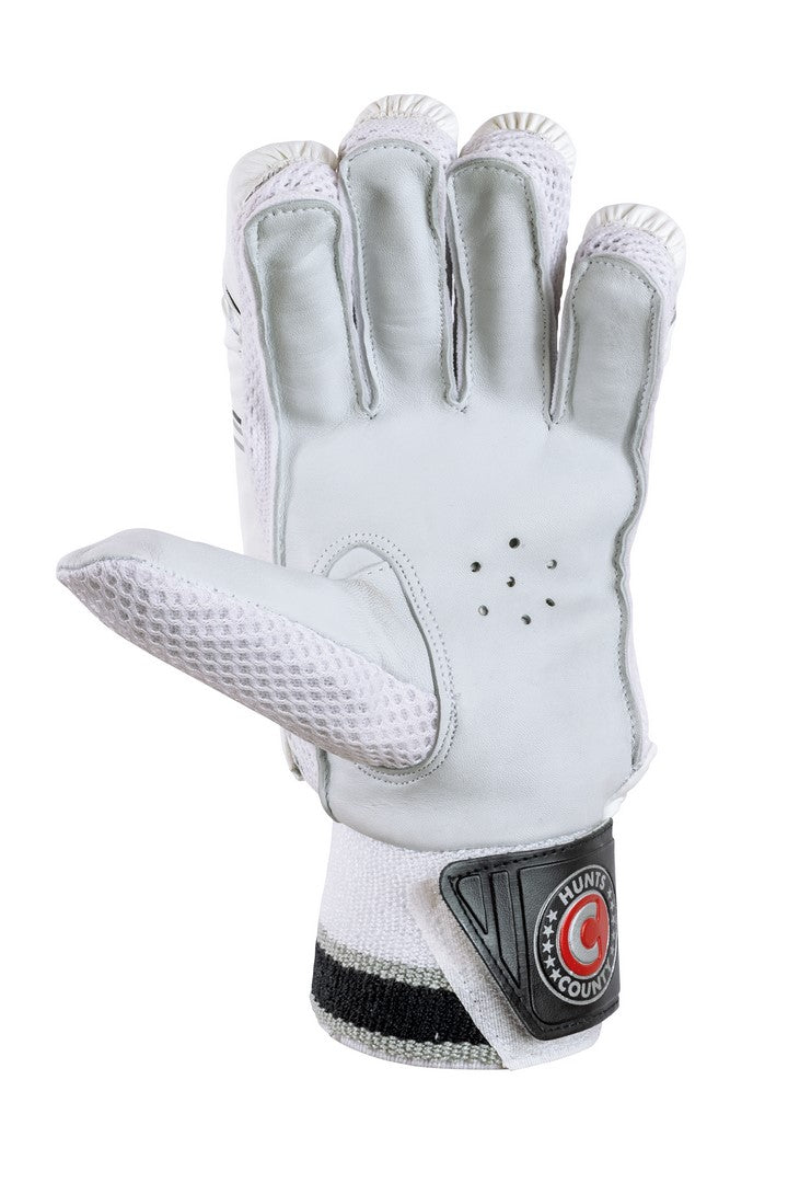 The Hunts County Envy Junior Batting Gloves by Hunts County are white gloves with black and gray accents, mesh ventilation, a full leather palm for durability, lightweight wrist protection, and a County Hunter logo on the wrist strap.