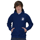 A teen boy with brown hair models the Martin Berrill Sports Great Tew CC Junior Navy Hoody, featuring a white chest graphic and kangaroo pocket. Made from soft cotton-faced fabric, he stands with hands in the front pocket against a plain white background.