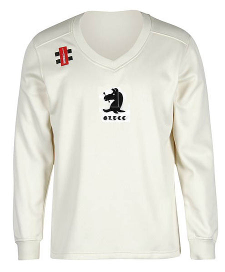 The Gray Nicolls Great Tew CC Pro Performance Sweater is a long-sleeved, off-white V-neck featuring a black and white bear logo, stylized "SLICE" text on the chest, and a red and black tag on the right shoulder.