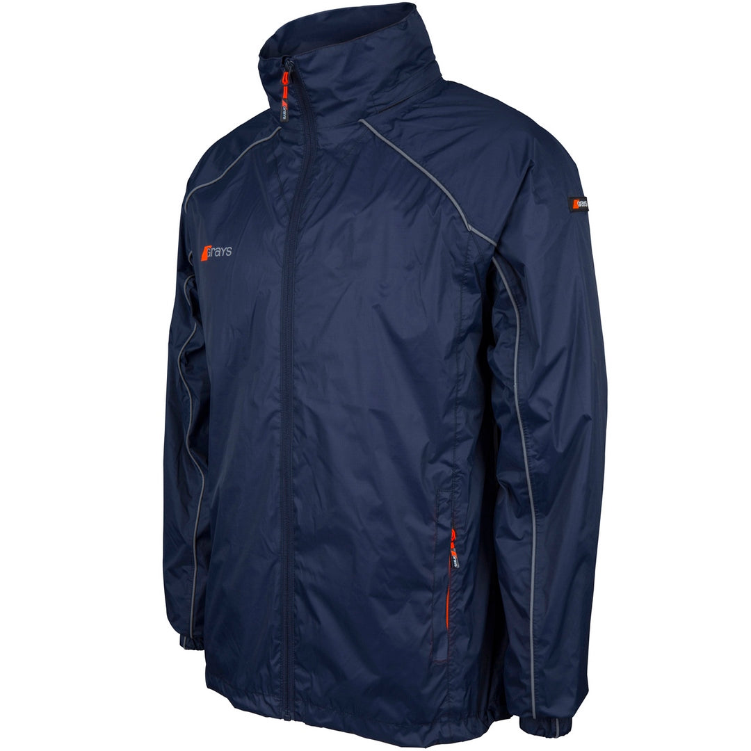 The Grays Junior Arc Rain Jacket is a kids' navy waterproof tracksuit jacket with a high collar, orange zipper accents, light gray piping on the shoulders and sleeves, zippered side pockets, and small Grays logos on the chest and sleeve.