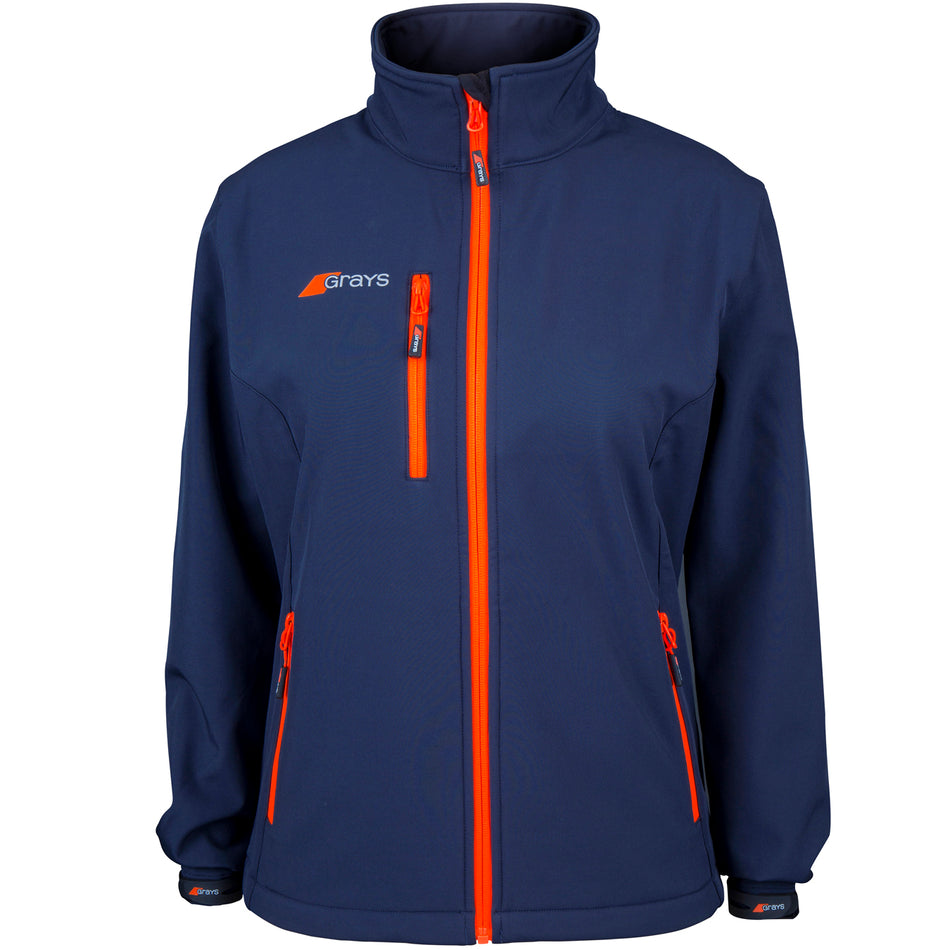 The Grays Ladies Radius Soft Shell Jacket in navy features bright orange zippers, a high collar, two front zip pockets, a small Grays logo on the left chest, and breathable water-resistant fabric for comfort in changing weather.