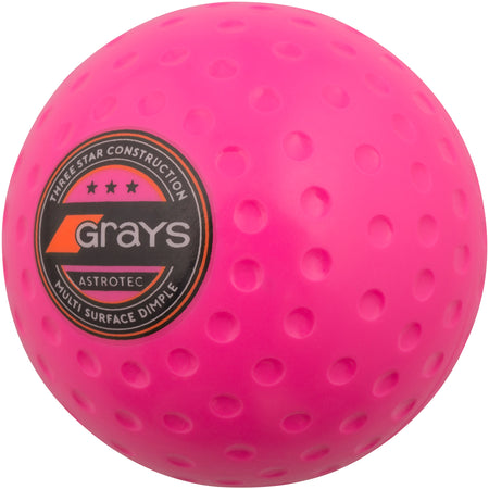 The Grays Astrotec Hockey Ball is a bright pink match ball with Three Star Construction and Multi Surface Dimple, featuring the black and orange Grays logo—ideal for county level play.
