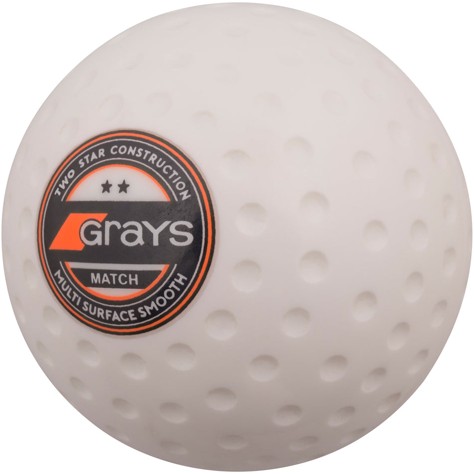A box of 60 white Grays Match Hockey Balls featuring a dimpled pattern and circular Grays logo sticker with "Two Star Construction," "Grays Match," and "Multi Surface Smooth.