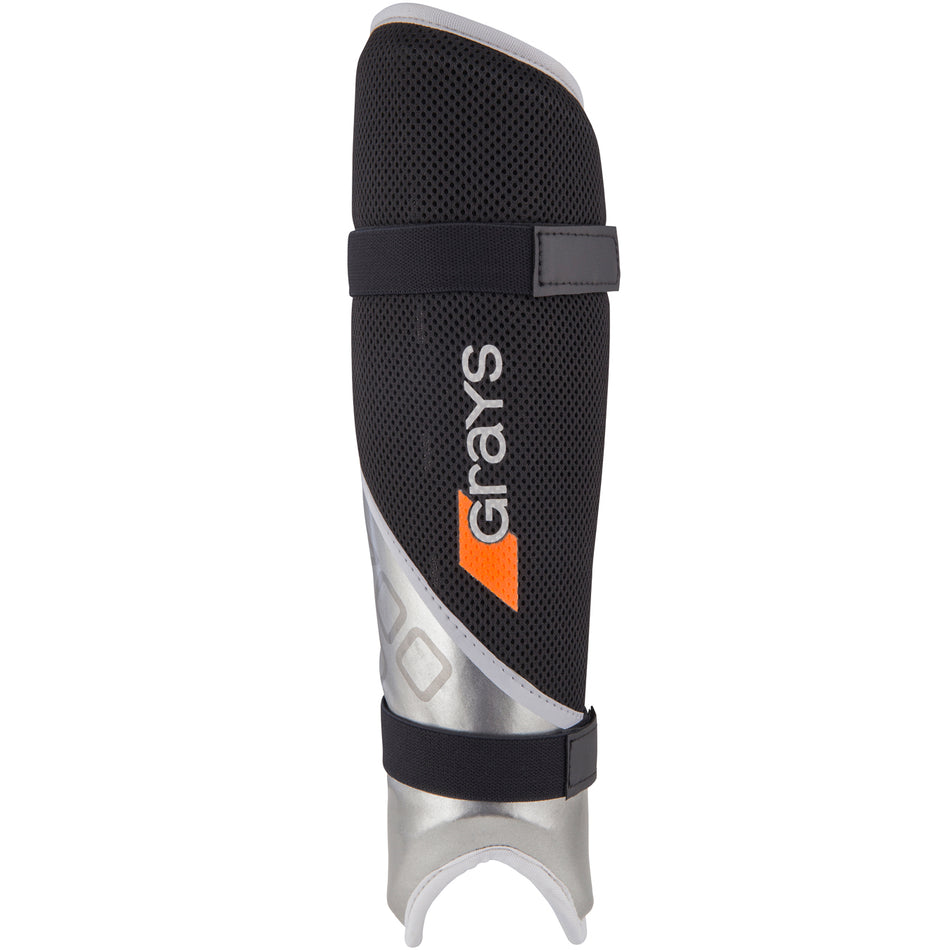 The Grays G700 Pro Shinguards feature a black and white mesh-textured design, a sculpted hard outer shell, two black straps, and "Grays" in white and orange lettering on the front.