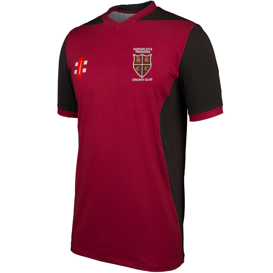 The Gray Nicolls Hatherley & Reddings CC Junior T20 Shirt features short sleeves, a maroon and black design, club crest, white Cricket Club chest text, sponsor logos in white/red, and moisture management for comfort during play.