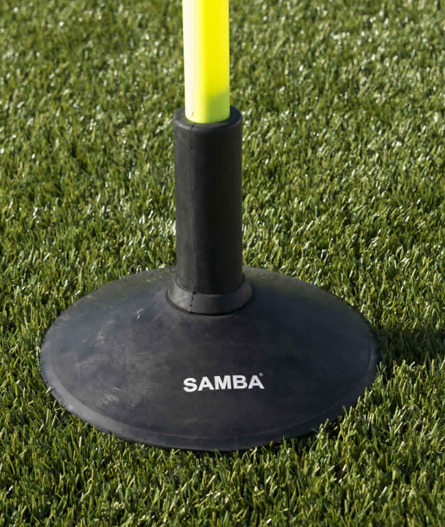 A close-up of a black Samba Sports Heavy Duty Rubber Boundary Pole Base supporting a yellow training pole, positioned on artificial green grass.