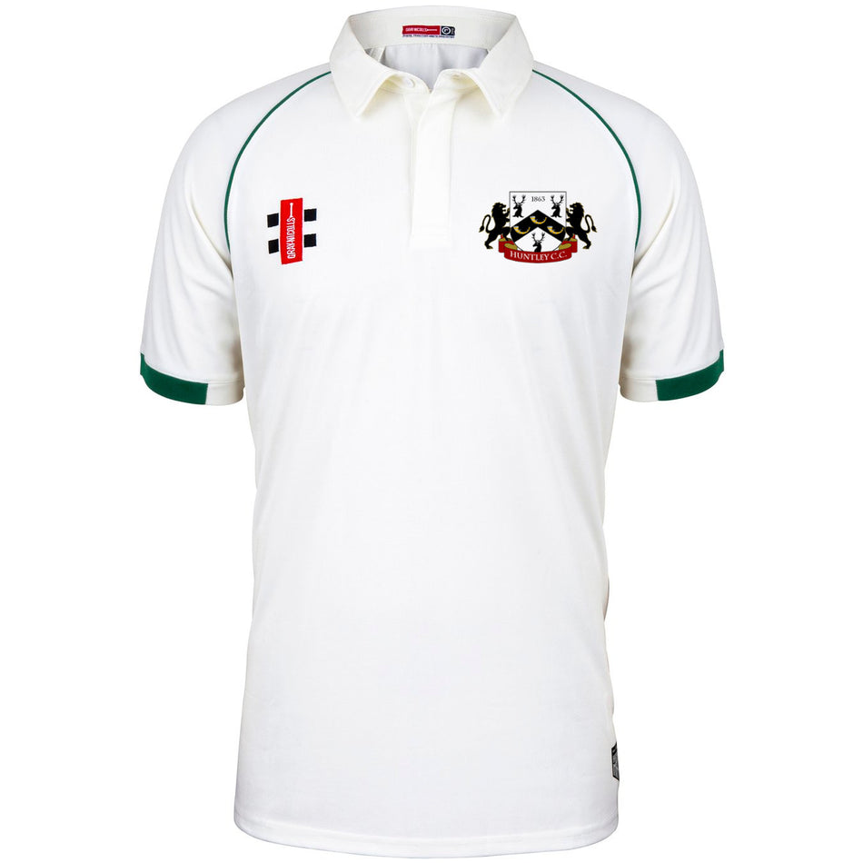The Huntley CC Matrix V2 Short Sleeve Match Shirt by Martin Berrill Sports is a white cricket shirt with green sleeve trim, with two embroidered logos: a red and black Gray Nicolls patch on the left chest and a crest on the right.