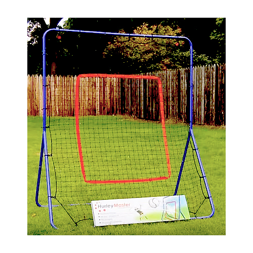 A blue and red Hurley Master Hurling Rebounder stands on a grassy lawn by a wooden fence, with a Hurley Master box at its base—ideal for hurling practice. Trees are visible in the background.