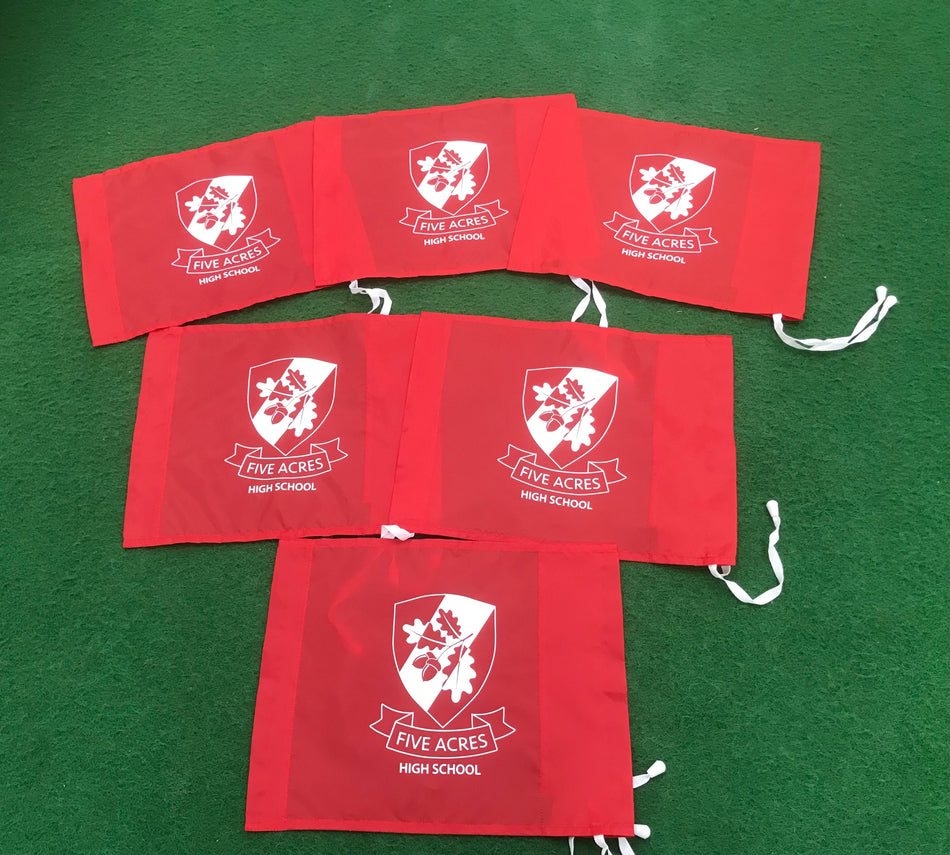 Five red drawstring bags with a white “FIVE ACRES HIGH SCHOOL” logo are displayed on a green surface—perfect for carrying Martin Berrill Sports Custom Printed Corner Post Flags (Single Colour Flag & Logo) at your next school event.