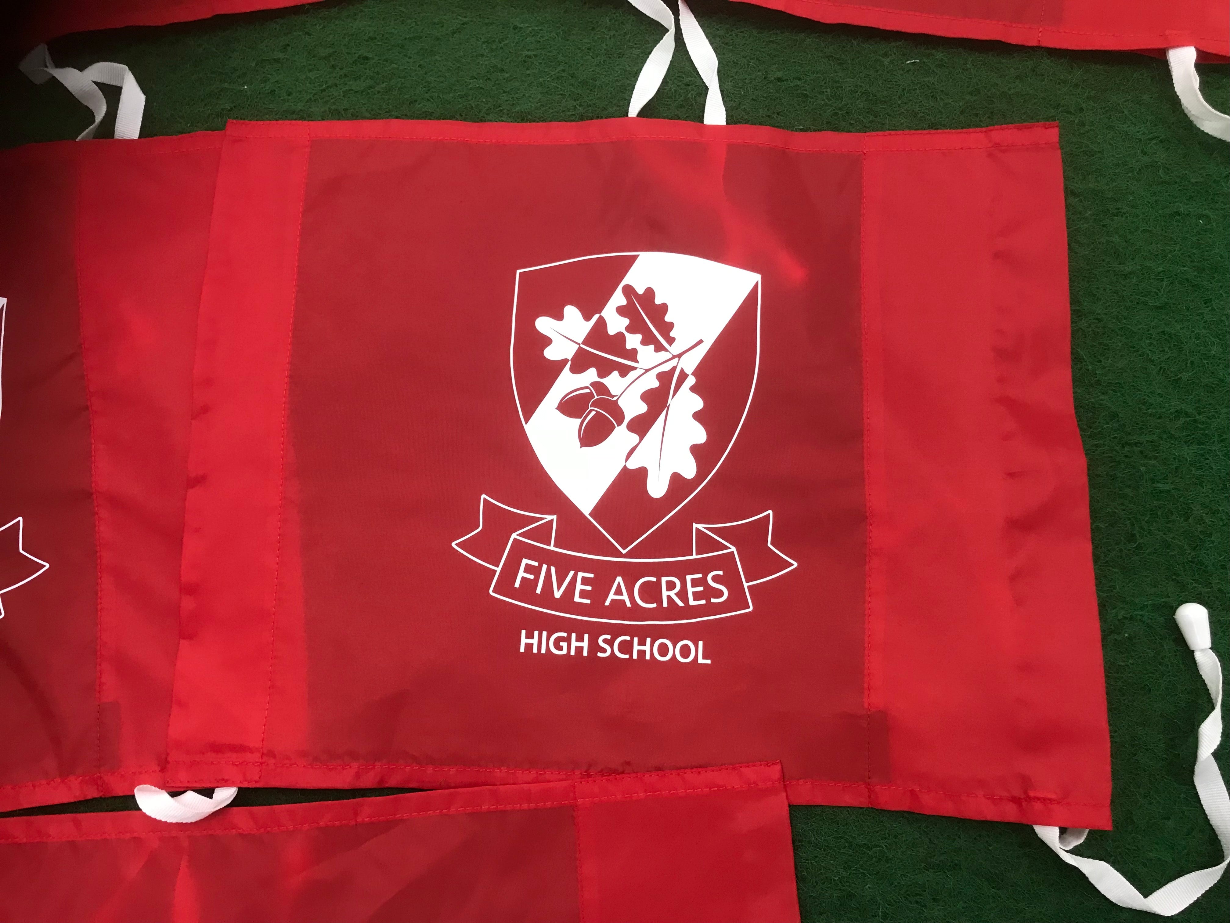 A single-colour red Custom Printed Corner Post Flag by Martin Berrill Sports features a white shield with oak leaves, acorns, and "FIVE ACRES HIGH SCHOOL" beneath. Perfect for branded flag posts or as personalised flags on your pitch.