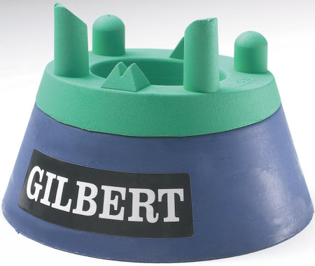 The Gilbert Adjustable Kicking Tee by Gilbert features raised grip points for optimal kicking practice, with a green and blue design and a black and white Gilbert logo on the front.
