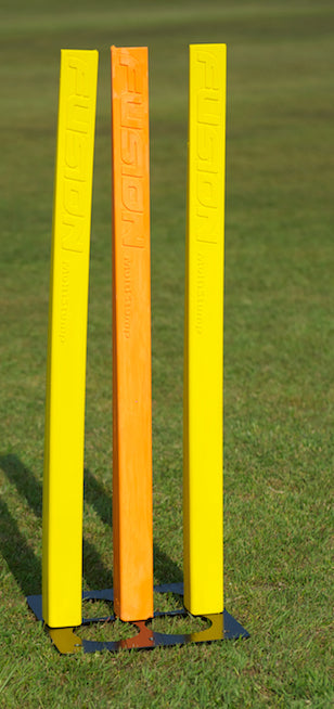 The Fusion Multi Stump Package by Fusion features two yellow and one orange stump on a multi-option base, standing upright on grass—ideal as a bright, effective cricket training aid.