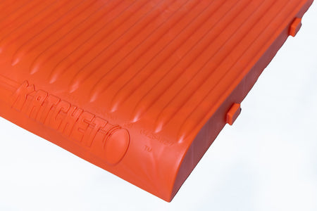 Close-up of the Katchet Training Aid by Katchet, featuring orange inflatable material with vertical ridges. Perfect for comfort during cricket training or catching drills. The pad is displayed against a white background.