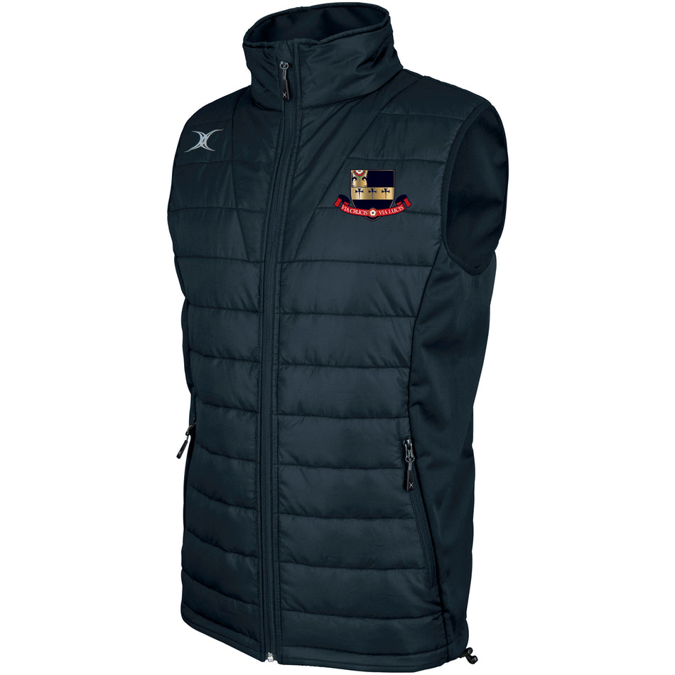 The Gilbert Kings School Pro Body Warmer is a dark blue, sleeveless puffer vest made from breathable technical fabric, featuring a high collar, zip front, two zip side pockets, and an embroidered crest and logo on the chest.
