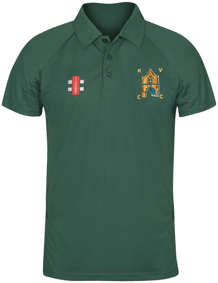 The Kingswood Village CC Matrix V2 Polo Shirt by Gray Nicolls is dark green with short sleeves, a buttoned collar, moisture-wicking fabric, a red and white chest logo, and an embroidered KVC crest on the right chest.