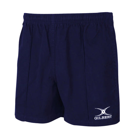 The Gilbert Kiwi Pro Rugby Short in dark navy features an elastic waistband, a loose fit, and the white Gilbert logo on the lower left leg. Made from durable sportswear fabric with no visible pockets.